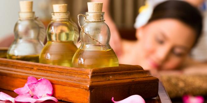 A woman with beautiful skin, and bottles of oil