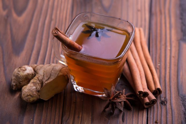 a mug of apple cranberry cider with cinnamon, star anise, and ginger