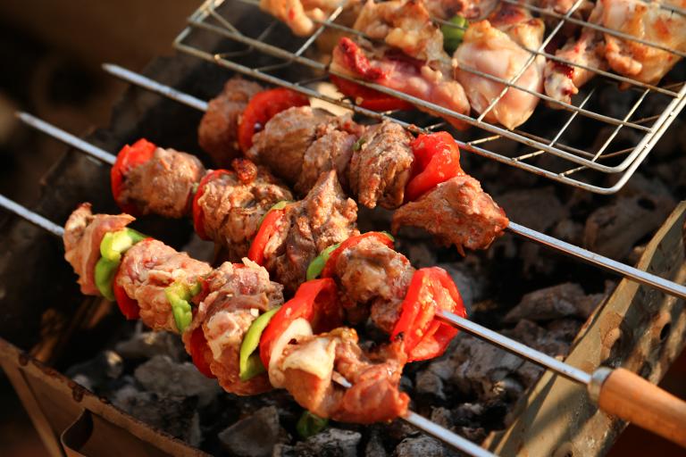 shish kebabs and chicken legs over a charcoal grill